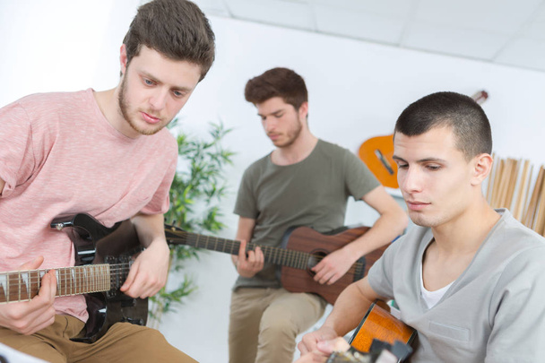 Young men playing guitars - Foto, afbeelding