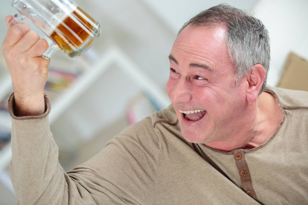 man holding a beer while laughing - Foto, Imagem