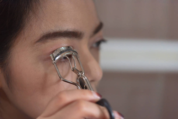 Крупним планом азіатська жінка намагається зробити її обличчя для поліпшення її техніки
. - Фото, зображення