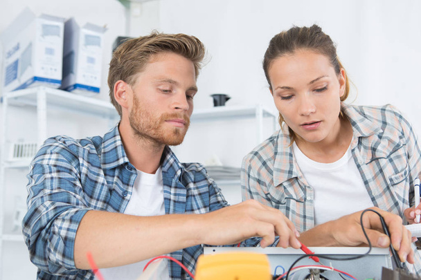 two workers holding multimeter checking voltage - Foto, immagini