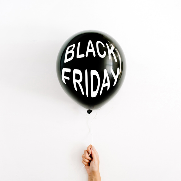 Black Friday sales discount concept. Woman hand hold black balloon on white background. - Foto, Bild