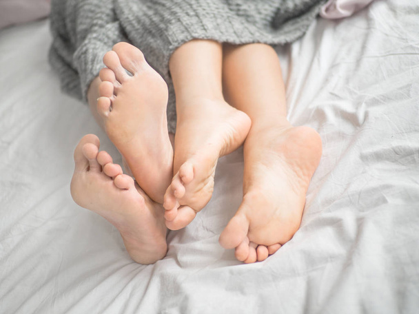 Detailní záběr nohou páru na posteli - Fotografie, Obrázek