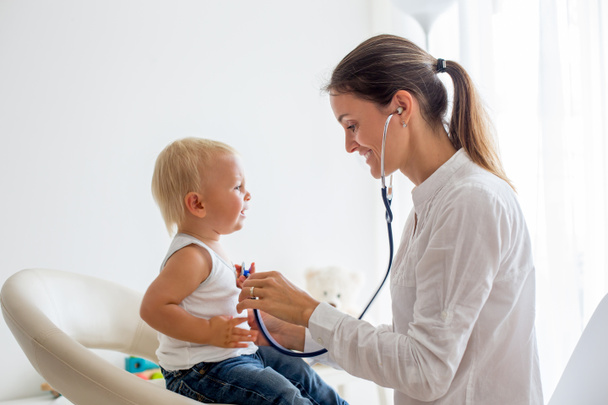 Педіатр вивчає хлопчика. Лікар використовує стетоскоп для прослуховування дитини та перевірки серцевого ритму
 - Фото, зображення