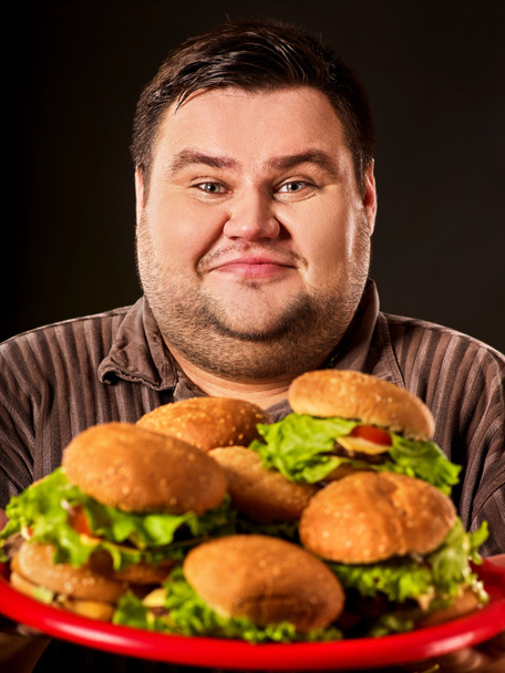 ハンバーガーのファーストフードを食べるコンテスト。デブ男を食べるファーストフード. - 写真・画像