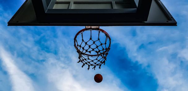 basketbalový koš a koule na obloze na pozadí - Fotografie, Obrázek