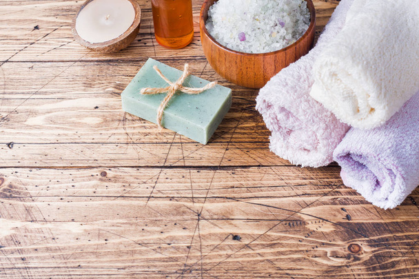 Spa and Wellness concept on wooden background. Terry towel and cosmetic oil for massage - Zdjęcie, obraz