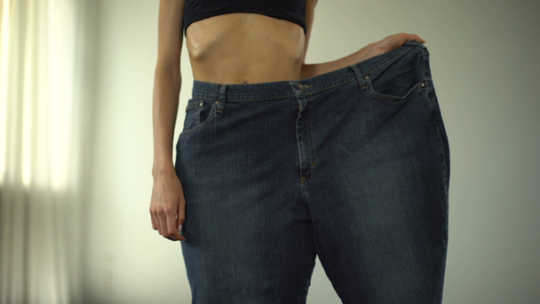 Anorexic κορίτσι που φοράει ένα παντελόνι πόδι, λίπος ανθρώπους vs κοκαλιαρα, η ταχεία απώλεια βάρους - Πλάνα, βίντεο