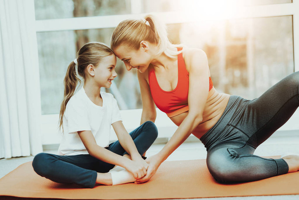 Mother And Daughter Sitting At Lotus Pose On A Carpet. Yoga Meditation Concept. Active Lifestyle. Relaxing Together. Fitness At Home. Holiday Leisure. Body Balance. Sport Exercise. - Фото, зображення