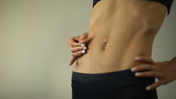 Sağlık, closeup anoreksik kız uzanan deri yağ katman, kilo kaybı etkiler - Video, Çekim