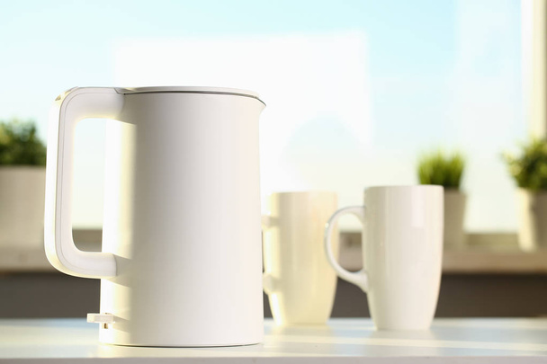Чайник і дві модні чашки на столі для
 - Фото, зображення