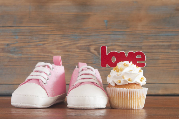 Slavnostní kulis pro oslavu narozenin s lahodnou cupcakes pro miminko na dřevěné pozadí - Fotografie, Obrázek