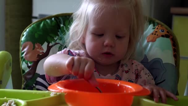 Маленький ребенок ест кашу за детским столом
. - Кадры, видео