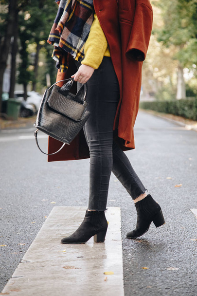 street style, donna attraente con cappotto marrone oversize, jeans neri, stivaletti e tote bag effetto coccodrillo. abito di moda perfetto per l'autunno soleggiato
. - Foto, immagini