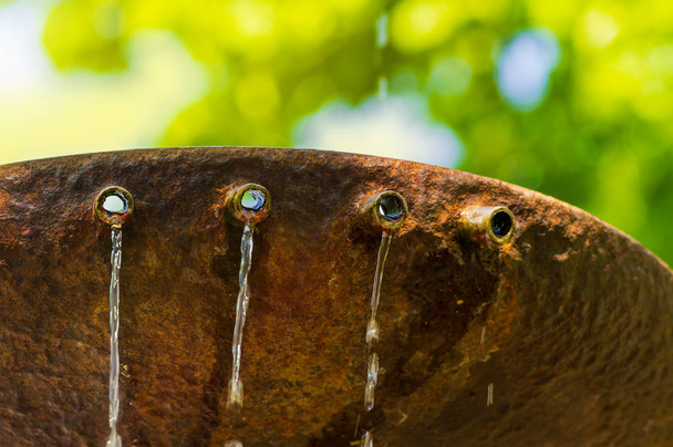 Small jets of water from pipes of a rusty fountain - Photo, Image