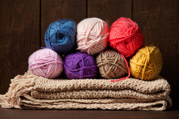 kuličky z vlněné vlákno pro pletení na dřevěné pozadí - Fotografie, Obrázek