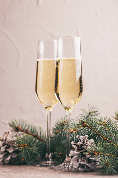 Два бокала шампанского с ветками елки и шишками на мраморном фоне. Горизонтальный вид. Копирование пространства
. - Фото, изображение