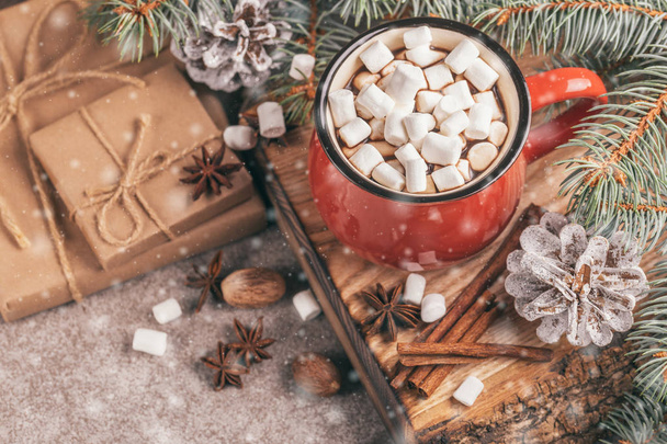 Red cup of hot cocoa with marshmallow on the wooden cutting board with Christmas decorations and snow effect. Top view. Copy space - Foto, Imagem
