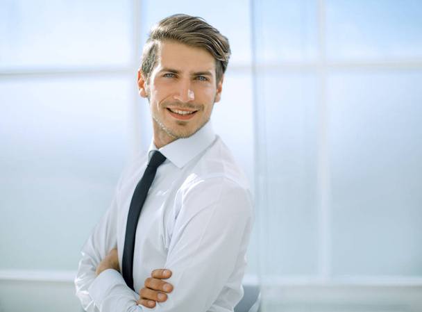 smiling businessman standing near the office window - Foto, Bild