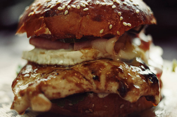 Burger with chicken meat on cutting board backlit vintage color - 写真・画像