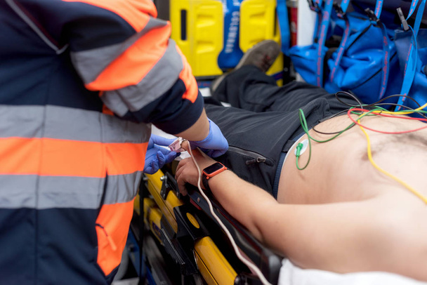 Médecin d'urgence vérifiant le pouls d'un patient dans l'ambulance
 - Photo, image