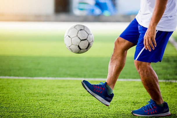 サッカー選手はジャンプし、人工芝上での目標にボールを撃ちます。トレーニング サッカー選手やサッカーの試合. - 写真・画像