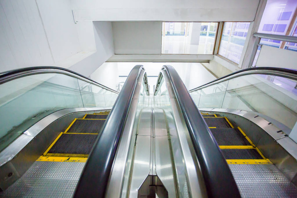 Escalator in business office building. Moving up staircase. electric escalator. yellow bands. metal line steel. yellow gray steel line. - Photo, Image