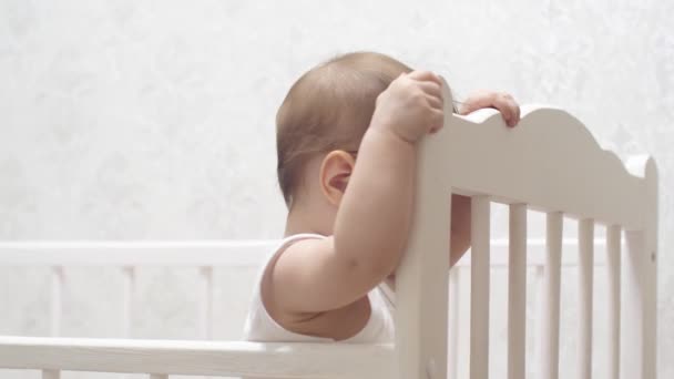 cute baby plays in a baby cot - Footage, Video