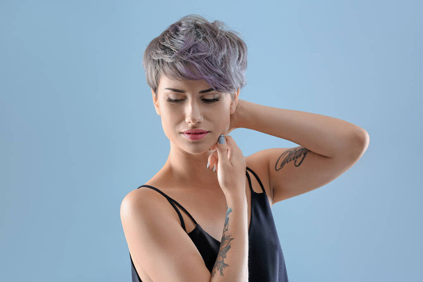 Young woman with tattoos on color background - Φωτογραφία, εικόνα