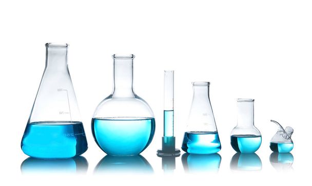 Vidros de laboratório para análise química com líquido azul na mesa contra fundo branco
 - Foto, Imagem