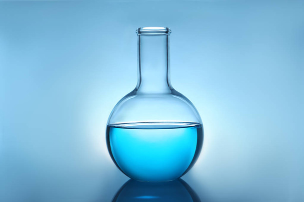 Flask with liquid on table against color background. Laboratory analysis - 写真・画像