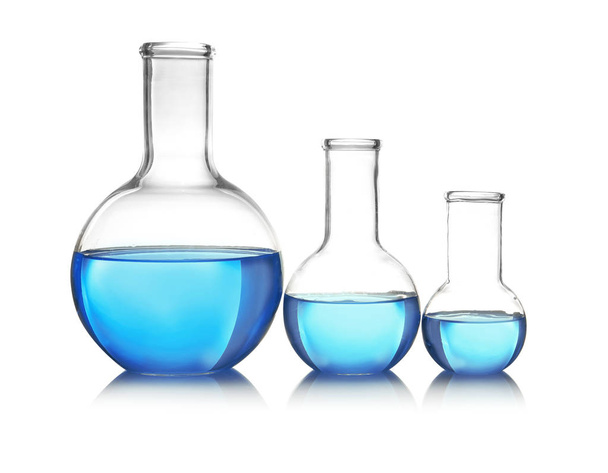 Flasks with blue liquid on table against white background. Laboratory analysis - Фото, зображення