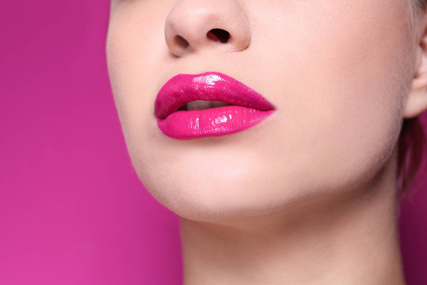 Beautiful young woman with perfect lips makeup on color background, closeup - Valokuva, kuva