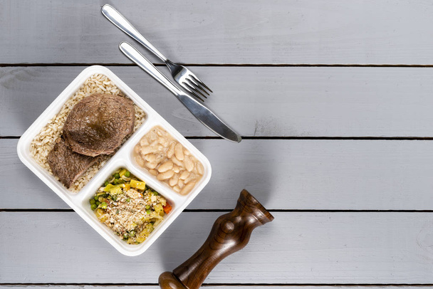 Witte bonen bruine rijst met gebakken vlees en groenten. Braziliaanse lunchbox. Vooruit maaltijd voorbereiding of dieet concept. bovenaanzicht. - Foto, afbeelding