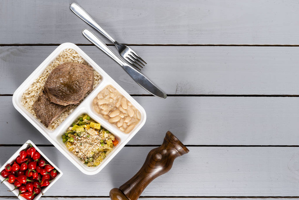 White beans brown rice with sauteed meat and vegetables. Brazilian lunch box. Ahead meal preparation or dieting concept. top view. - Photo, Image