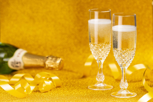 Okulary pełna szampana i złote błyszczące tło - Zdjęcie, obraz