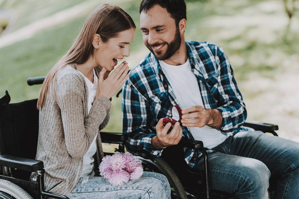 Man on Wheelchair Makes Marriage Proposal in Park. Disabled Young Man. Woman on Wheelchair. Date in Summer Park. Romantic Relationship. Recovery and Healthcare Concepts. Happy Couple. - Foto, Imagen