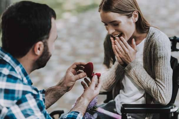 Man on Wheelchair Makes Marriage Proposal in Park. Disabled Young Man. Woman on Wheelchair. Date in Summer Park. Romantic Relationship. Recovery and Healthcare Concepts. Happy Couple. - 写真・画像