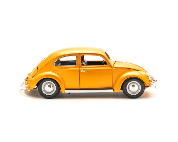 Nahaufnahme Studioaufnahme Seitenansicht eines orangen Spielzeugautos isoliert auf weißem Hintergrund, kleines Metall-Modellauto - Foto, Bild