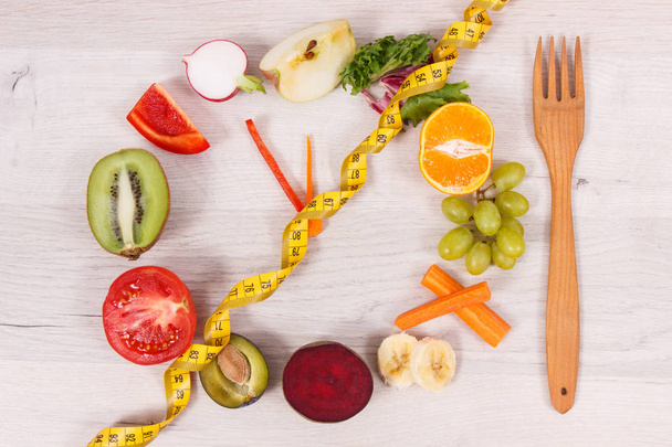 Tape measure and clock made of fruits and vegetables containing natural minerals and vitamins, time to diet and slimming concept - Foto, immagini