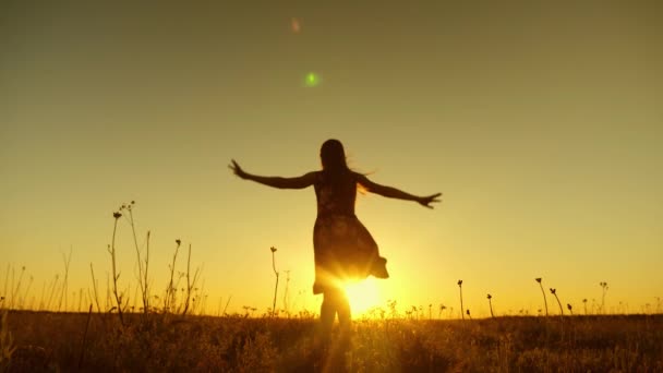 Onnellinen tyttö hyppää korkealle auringon laskiessa lämpimänä iltana. Hidastus
. - Materiaali, video