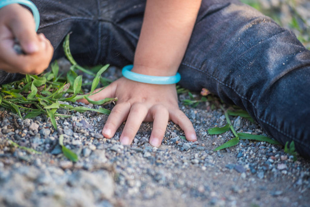 enge Sicht auf kleine Mädchenhände beim Spielen auf dem Boden mit Seele oder kleinen Steinen. - Foto, Bild