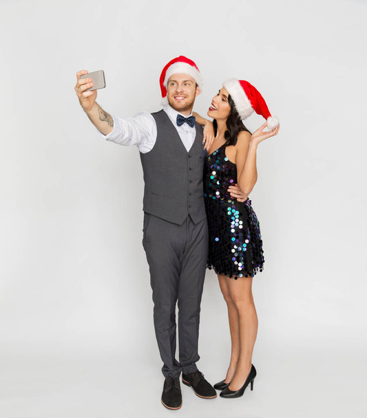couple in santa hats aking selfie at christmas - Фото, зображення