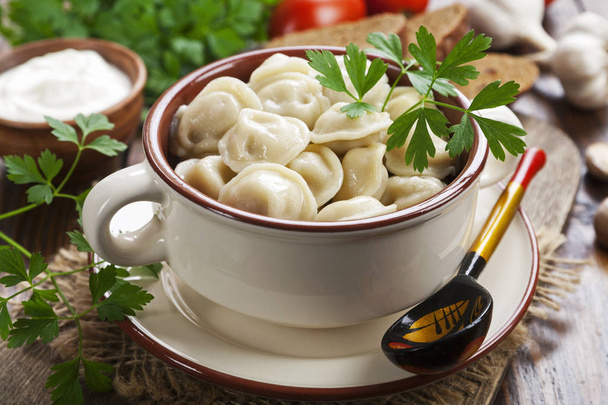 Delicious dumplings in the pot on the table - Photo, Image