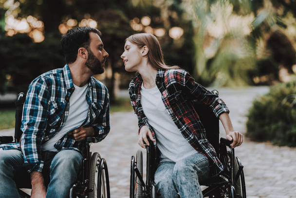 Couple of Disabled People on Wheelchairs in Park. Disabled Young Man. Woman on Wheelchair. Date in Summer Park. Romantic Relationship. Recovery and Healthcare Concepts. Happy Couple. - Photo, Image
