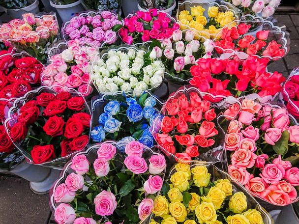 Bouquets of different varieties of roses are sold in the street market. Multi-colored flowers. - Фото, зображення