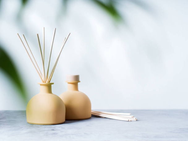 aroma reed fragrance diffusers with rattan sticks with palm leaf on light grey background - Foto, immagini