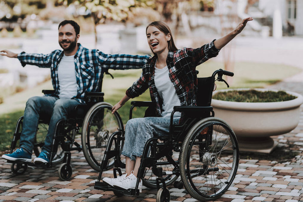 Disabled People on Wheelchairs Have Fun in Park. Disabled Young Man. Woman on Wheelchair. Relaxing in Summer Park. Fun in Summer Park. Recovery and Healthcare Concepts. Cheerful People. - Photo, Image