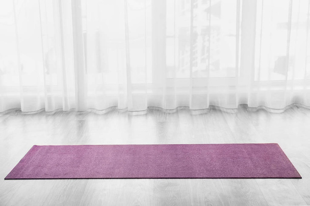 Esterilla de yoga en el suelo en interiores
 - Foto, imagen