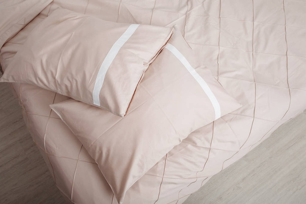 Bedclothes on the bed made with pillows. - Фото, изображение