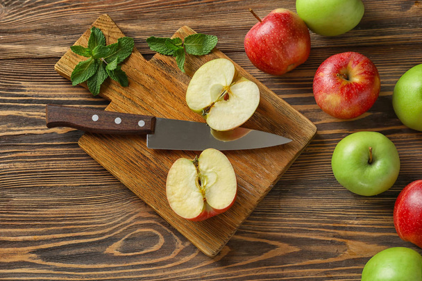 Board with fresh apples and knife on wooden table - Photo, Image